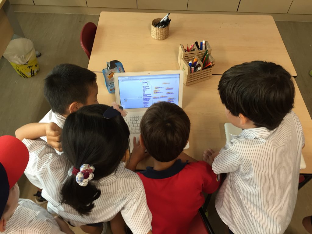 Kids huddled around Scratch laptop